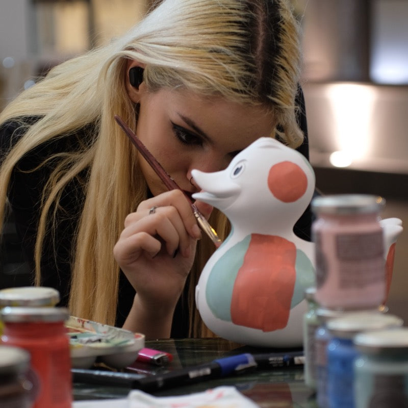 Die Künstlerin Ion bemalt eine Art Duck Kunstobjekt aus Kunstsandstein