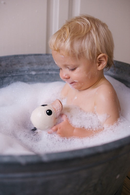 Kind spielt mit einer Kawan Naturkautschuk Badente in einer Badewanne