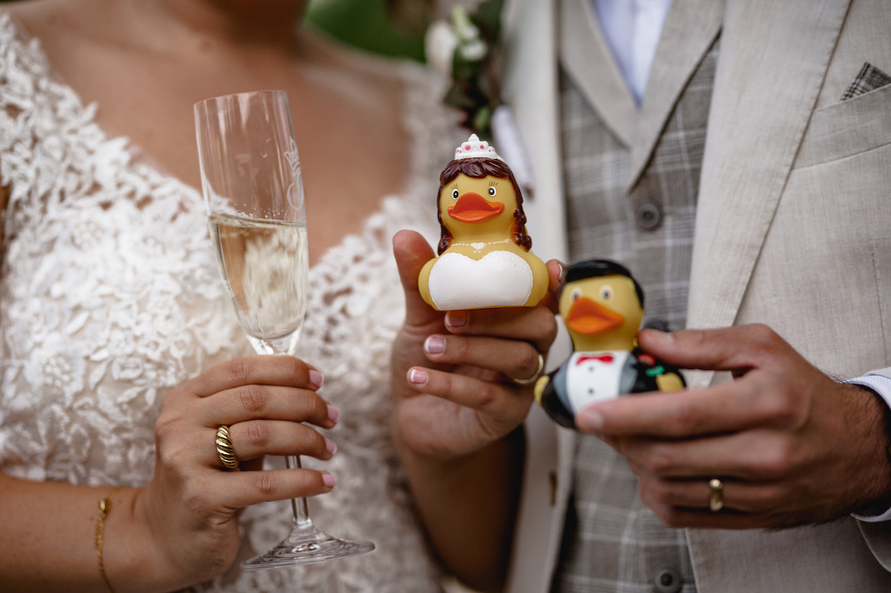 Eine Braut und ein Bräutigam halten während ihrer Hochzeit zwei Hochzeit Badeenten